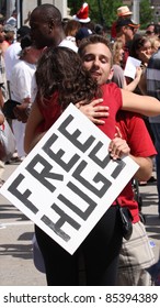 OTTAWA, CANADA – JULY 1: A Young Man With A 'Free Hugs' Sign Embraces A Stranger During Canada Day Festivities On July 1, 2011 In Downtown Ottawa, Ontario. Canada Day Is An Annual National Holiday.