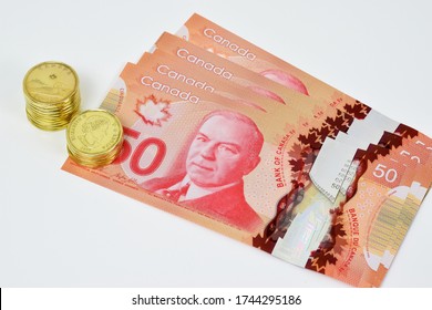 Ottawa, Canada - May 22, 2020: $50 (Fifty) banknotes and $1 (One) coins of Canadian dollar illustrative image concept for Canadian economic business development.