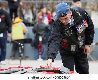 OTTAWA, CANADA - NOVEMBER 11, 2015: An Unidentified Canadian War Veteran Places A Poppy On The Tomb Of The Unknown Soldier At The National War Memorial In Ottawa.  