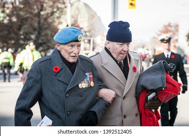 OTTAWA, CANADA - NOVEMBER 11, 2018: Two Canadian Army War Veteran, Senior Men, With Their Medals And Remembrance Poppy, Paying Respects To Dead Soldiers On Remembrance Day

