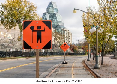 Ottawa, Canada - October 14, 2021: Traffic Control Person Ahead Sign Due To Construction Work In Downtown Of The City. Orange Warning Road Sign On The Street Near The National Gallery