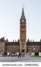 Ottawa, Canada - September 19, 2021: Parliament Building With Canadian Flag In The Capital Of Canada, Ottawa Against Sky. Peolpe Walking Near Centennial Flame In The Evening