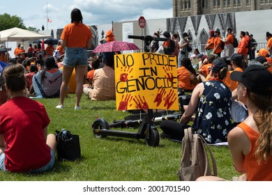 OTTAWA - JULY 1, 2021: Protesters holding signs at rally on Parliament Hill following recent discovery of unmarked graves at former residential schools designed to help assimilate indigenous people.