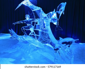 OTTAWA, ON - FEB 12, 2017: Ice Sculpture Of Athletic Man Surfing Between Dolphins Illuminated At Night In Confederation Park, Winterlude Event, On Feb 12, 2017 In Ottawa, ON, Canada