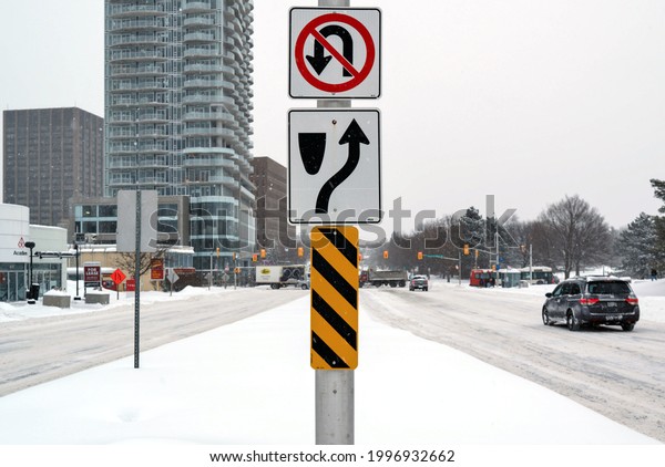 Ottawa, Ontario, Canada - 2021-02-15: Life
in a cold city - snowscapes from Ottawa - road signage on a traffic
light in the middle of a snowy Carling
Ave.
