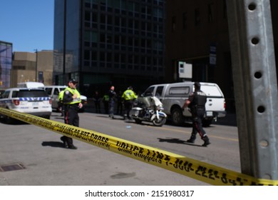 Ottawa, Ontario, Canada - April 30, 2022: Yellow police tape surrounds a section of Queen Street downtown as Ottawa Police Service officers investigate an incident during Rolling Thunder protests.