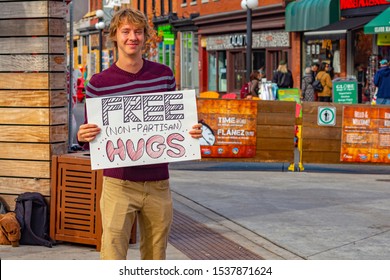 OTTAWA, ONTARIO, CANADA - OCTOBER 21, 2019: A Man Stands In The ByWard Market Holding A Sign Offering Free Hugs On The Day Of The Canadian Federal Election.