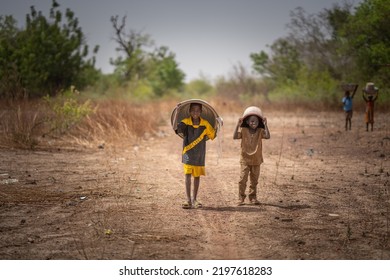 Ouagadougou, Burkina Faso: April 2022 African Children Holding Buckets Of Water Over Their Heads. Drought In Africa. Selective Focus. 