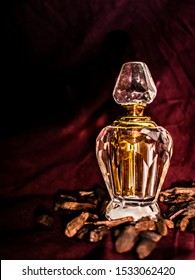 Oud Attar Shot Composed Using Oud Wood Chips And Maroon Tshirt For Background