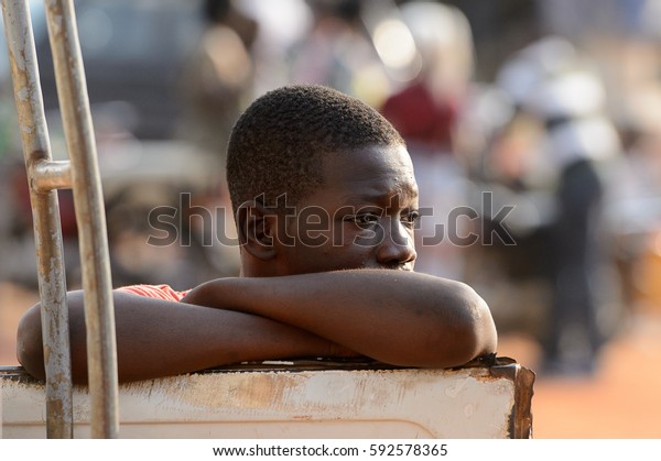 OUIDAH, BENIN - Jan 10, 2017:\
Unidentified Beninese man puts his elbows on a car at the local\
market. Benin people suffer of poverty due to the bad\
economy