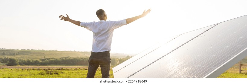 oung engineer is checking an operation of sun and cleanliness of photovoltaic solar panels on a sunset. Concept: renewable energy, technology, electricity, service, green, future