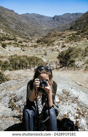 oung Woman Capturing Mountain Majesty through the Lens of her camera