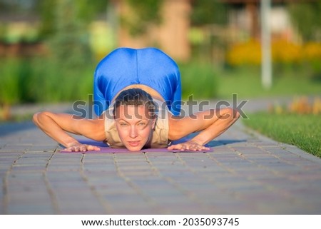 oung woman doing yoga in a beautiful summer park. Harmony, meditation and travel concept. Healthy lifestyle	