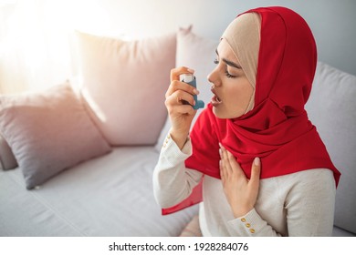 Oung Woman Treating Asthma With Inhaler. Asthmatic Muslim Woman Using Inhaler. Girl Suffering Asthma Attack Reaching Inhaler. Mid Adult Muslim Woman Using Asthma Inhaler