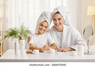 Our Beauty Moments. Portrait Of Young Mother And Her Teenage Daughter Who Have Organized Home Beauty Salon And Spend Spa Day Together. Mom And Daughter In Morning With Drops Of Cream On Their Noses.