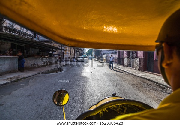 Our cocotaxi driver pulls off the Malecon &\
passes some open shop windows one morning in Havana, the capital of\
Cuba in August 2014.