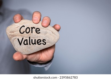 Our core values symbol,  Businessman holds in his hand a stone with the principles of his company engraved on it,  Business and Our core values concept. Copy space. - Shutterstock ID 2395862783