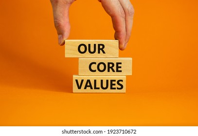 Our Core Values Symbol. Concept Words 'Our Core Values' On Wooden Blocks On A Beautiful Orange Background, Businessman Hand. Business And Our Core Values Concept. Copy Space.