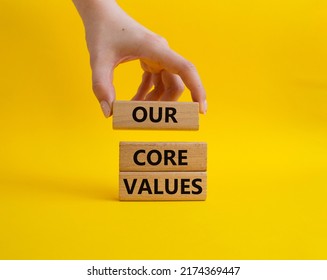 Our Core Values Symbol. Concept Words 'Our Core Values' On Wooden Blocks. Beautiful Yellow Background. Businessman Hand. Business And Our Core Values Concept. Copy Space.