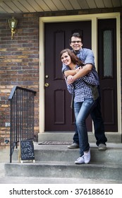 Our First Home Sign With New Home Owners On Front Door Step