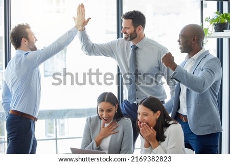 Our greatest accomplishments have come from team work. Shot of a group of businesspeople celebrating while using a laptop in an office at work.