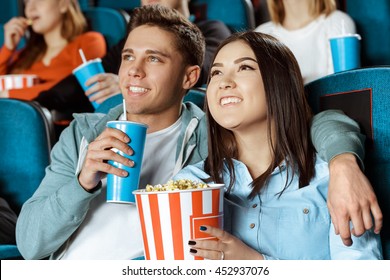 Our New Favorite Movie. Young Happy Loving Couple Hugging Watching Movies At The Local Cinema Together