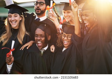 Our parents are so proud of us. Shot of a group of cheerful university students on graduation day.