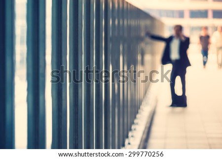 Out of focus anonymous business man talking on his cell phone inside a giant modern building