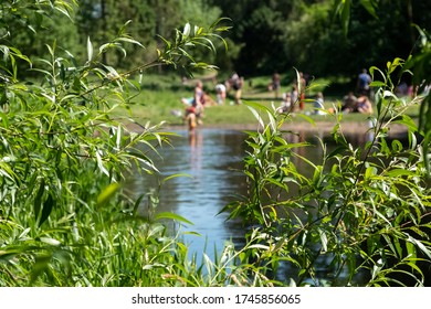 Out Of Focus Children Wild Swimming And Fishing In The River Chess At Chorleywood, Hertfordshire UK. Swimming Oudoors In Natural Habitats Is Allowed During The Coronavirus Lockdown.