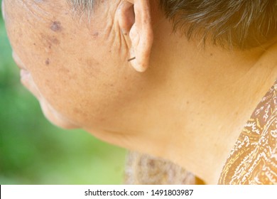 Out of focus close up The wrinkles of the half face old woman asian show Wooden earrings. - Powered by Shutterstock