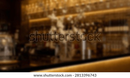 An out of focus image of a bar interior with shelves full of bottles and soft lighting creating an abstract background.