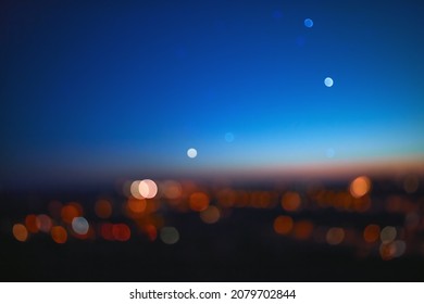 Out of focus landscape with bokeh star and distant city streetlights.