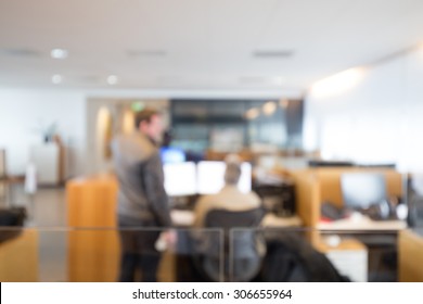 Out Of Focus Shot Of Two Coworkers Working Together In An Office Setting