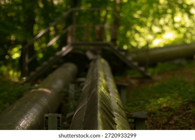 Out of focus support pipe with rust, Soft background blur emphasizing utility pipe details, Atmospheric closeup of support pipe with textured metal and muted tones