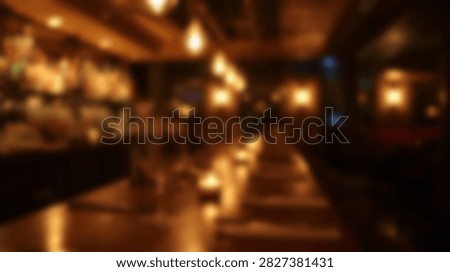 An out of focus view of a bar interior with warm ambient lighting creating a cozy atmosphere.