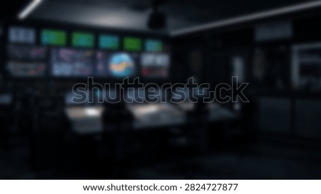 Out of focus view of a high tech command center or television studio control room with glowing screens