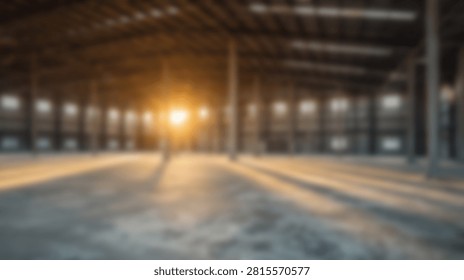 Out of focus view of a spacious vacant hangar featuring concrete floors and golden hour sunlight streaming through windows