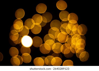 Out of focus warm yellow light circles create a beautiful bokeh effect on a black background, perfect for festive or dreamy designs. - Powered by Shutterstock - Get 15% off with code: PIKWIZARD15