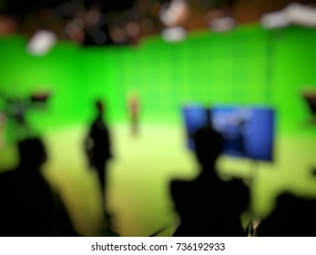Out Of Focused And Silhouetted People In Green Screen Studio, Behind The.scene Of Pre Production Of News Broadcasting.