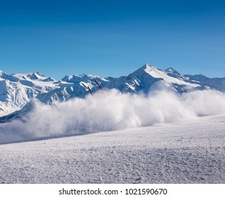 Out Of Frame Skiier With Flying Snow Powder At A Downhill Ski Course In The Italian Alps With Stunning Mountainscape Background, Bormio, Italy