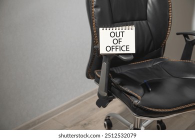 Out Of Office message on notepad with a office chair.