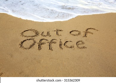 Out Of Office, A Message Written In The Sand At The Beach. 