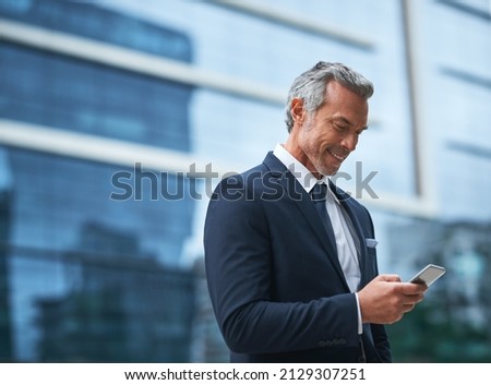 Out of the office but they still contacting me. Shot of a handsome mature businessman in corporate attire using a cellphone outside during the day.