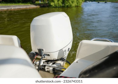 Outboard engine. Close up of white outboard motor on the lake. Boat swimming on the river.