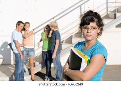 Outcast Sad Girl At University With Group Of Friends Behind