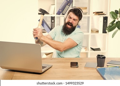 Outdated software. Computer lag. Reasons for computer lagging. How fix slow lagging system. Hate office routine. Man bearded guy headphones office swing hammer on computer. Slow internet connection. - Shutterstock ID 1499323529
