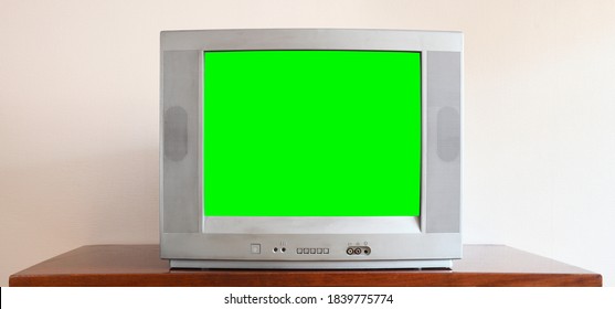 An Outdated Vintage Silver TV With A Blank Green Screen Sits On A Vintage Table In A 1990s Tenement House.