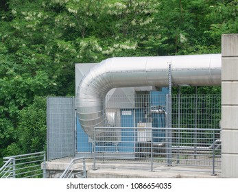 Outdood Warm Forced Air Furnace With Big Pipeline  Used To Heating A Large Building, Trees In Background
