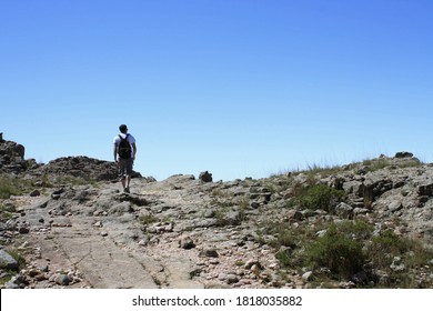 Outdoor Activities. Hiking. View Of A Young Adult Hiker, Walking Along The Dirt Path In The Rocky Mountain Top.  