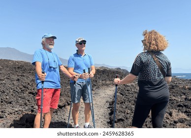 Outdoor activity in nature concept. Happy group of sporty mature friends enjoying healthy lifestyle hiking along a rocky beach in southern Tenerife enjoying nature and travel - Powered by Shutterstock